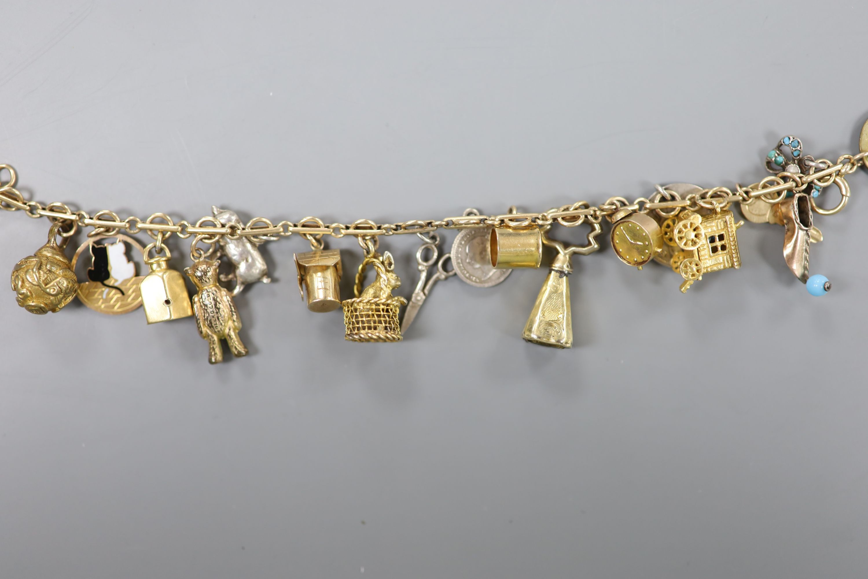 A 9ct charm bracelet, hung with assorted charms, gross weight 38.1 grams.